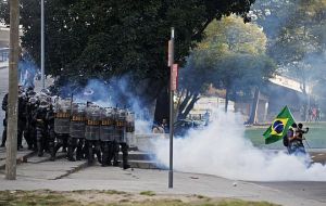 Riot police in full gear clash and disperse protestors outside the Maracana stadium