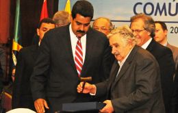 The Venezuelan president receives the gavel from his Uruguayan peer Mujica 