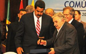 The Venezuelan president receives the gavel from his Uruguayan peer Mujica 