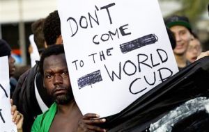 A man discourages people from attending the World Cup soccer tournament during a march demanding better public services in Rio de Janeiro