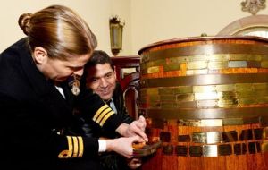 Commander Sarah West followed the tradition of nailing a brass plaque bearing the ship’s name onto a barrel of rum 