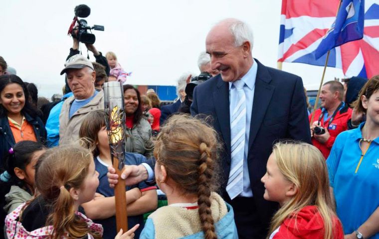MLA Summers holding the baton surrounded by children (Pic by FIOGA)