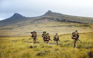 With the Union Jack flying the team in full kit marches across East Falkland 
