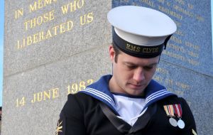 His head bowed in reverence, HMS Clyde’s AB Gaiger honors the 255 Britons killed 32 years ago to liberate the Falklands. (Pic RN)