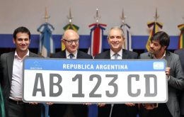 Timerman and other officials hold the enlarged prototype of the Mercosur cars' number plate 