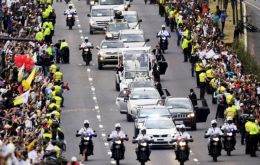 Tens of thousands of people lined the route from the airport, at times rushing police to touch the car and throw flower petals before it.
