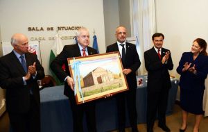 Buzzi presented First Minister Jones with a painting from a local Gaiman artist which depicts the chapel of Bryn Crwn