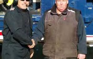  British International helicopter pilot Martin Elstow hands the time capsule to David Pole-Evans of Saunders Island