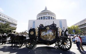 A gilded horse-drawn coach carried Casamonica's body to the church, where mourners were showered with red rose petals.