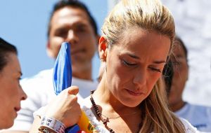 The government supporters also threw bottles at Lopez's wife, Lilian Tintori, as she made her way through the police barricade to the courthouse.