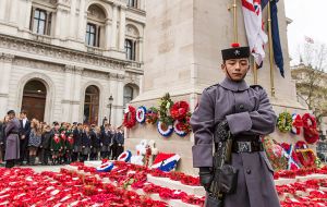 The Cenotaph to the “The Glorious Dead” in central London surrounded by poppies and a ceremonial armed guard 
