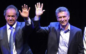 Daniel Scioli and Mauricio Macri are joined by their wives on the stage at the end of the event, the first in Argentine history