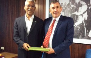 MLA Hansen presents President Granger with a gift from the Falkland Islands government