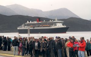 Passengers after landing at the Ushuaia jetty, with the Queen Mary 2 anchored in the bay