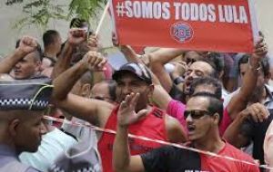 A few hundred government supporters wearing red shirts and holding banners that read “There will not be a coup” stood outside Lula's home in Sao Paulo.