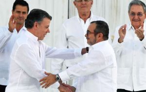 Colombian President Juan Manuel Santos and FARC commander Rodrigo Londoño, Timochenko, formally ended the long and brutal war, then shook hands.