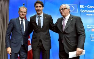Canadian PM Justin Trudeau (C) signed the treaty along with heads of EU institutions, a step that should enable a provisional implementation of the pact early in 2017.