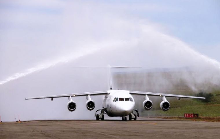 The first symbolic flight with a BAE 146-200 lands in Ushuaia and is received with the friendly arch of rain at the airport  