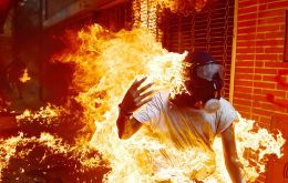 In a dramatic scene caught by a photographer, a protestor was severely burned when the gas tank of a police motorcycle exploded during clashes 