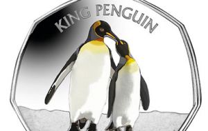 The seven-sided coin with a vivid color application features a large, adult male king penguin with his smaller female companion lovingly touching their beaks.