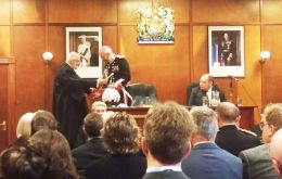 Governor Phillips CBE during the Oath of Allegiance ceremony at the Court and Assembly Chamber receives the ceremonial sword from the Speaker of the House Keith Biles