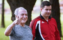 Dressed in jogging gear and flanked by bodyguards, a grinning Temer gave the “thumbs-up” sign and declared he had “fully recovered”