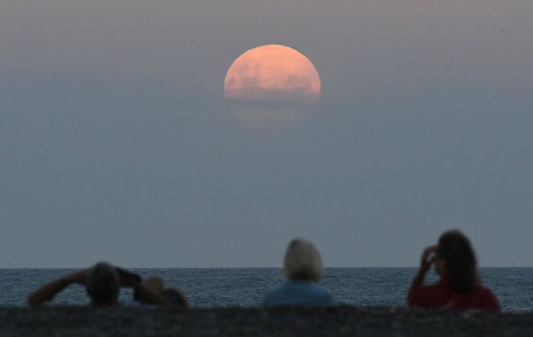 The moon, about as large as it can be in the sky, will turn a blood red color in the hours before dawn. 