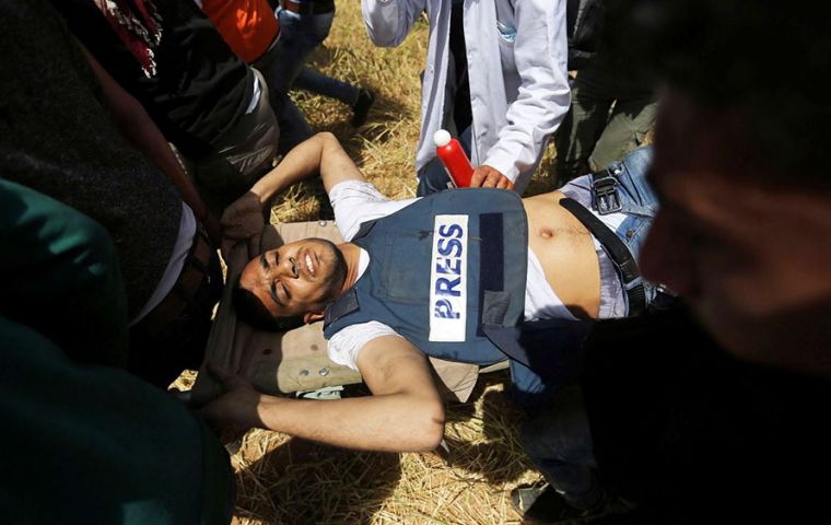 Yaser Murtaja wounded wearing a vest with the word “press”. He worked as a photographer for the Ain Media agency, based in Gaza. Photo: Ibraheem Abu Mustafa / Reuters