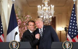 Trump held Macron's hands, showered him with compliments and even brushed what he said was a piece of dandruff off of Macron's suit. 