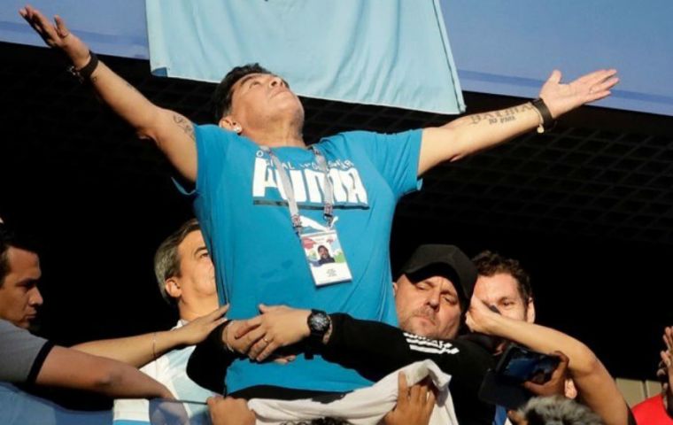 Maradona struggled to walk as he was aided by one man in black and followed by two others as he was led inside a luxury box