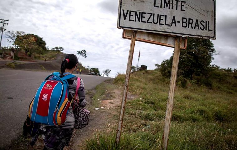 Fearful Venezuelan immigrants lined up in smaller numbers to enter Brazil at the only border crossing between after violent protests by Brazilian residents