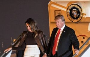 Donald Trump and his wife leave the Air Force One behind at Buenos  Aires' Ezeiza airport.