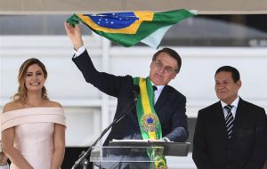 From the Planalto Palace addressing the crowd next to vice president ex general Hamilton Mourao, Bolsonaro waves a Brazilian flag 