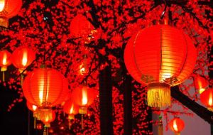 Red Chinese lanterns hang in streets; red couplets are pasted on doors; banks and official buildings are decorated with red New Year pictures depicting prosperity