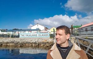 Lawyer Ujhelly at the Stanley Jetty with the iconic Falklands' placard