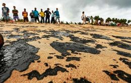 As ocean currents brought large globs of crude to shore near Recife, locals rushed to the normally picturesque beaches and used their bare hands to remove the oil