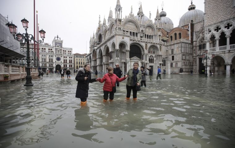 Despite the emergency, tourists larked around in the flooded St Mark's Square in the sunshine, snapping selfies in their neon plastic boots