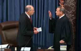 In a hushed chamber Supreme Court Chief Justice John Roberts, clad in a traditional black robe, raised his right hand as he was sworn in to preside over the trial