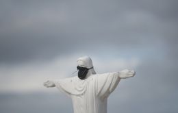 A replica of Christ the Redeemer statue wearing a mask. FABIO TEIXEIRA / GETTY IMAGES.