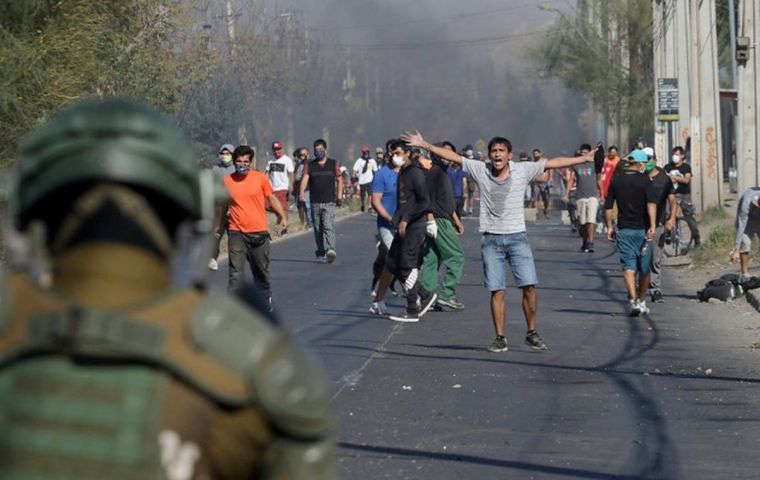 A group of protesters threw rocks, shouted and burned piles of wood along a street in the destitute neighborhood on Santiago's southern fringe