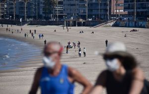 A balmy sunny weekend along the Uruguayan coast with people enjoying the good weather using face masks   