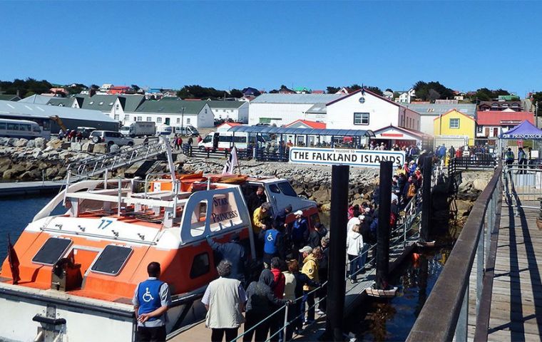 Cruise tourists landing in Stanley pier during a busy sunny summer day