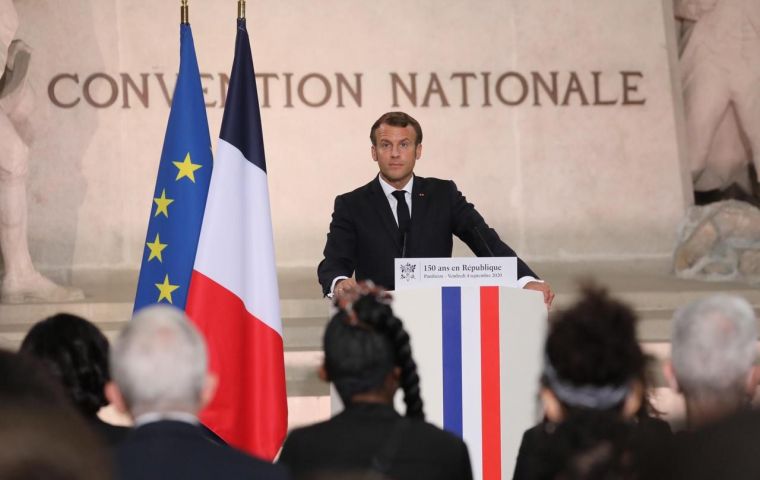 In the Paris Pantheon, a mausoleum to France's heroes, Macron handed five new citizens their French papers in a solemn ceremony