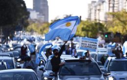 Pedestrians and vehicles with hundreds of Argentine flags during the last demonstration surrounding the Buenos Aires obelisk  