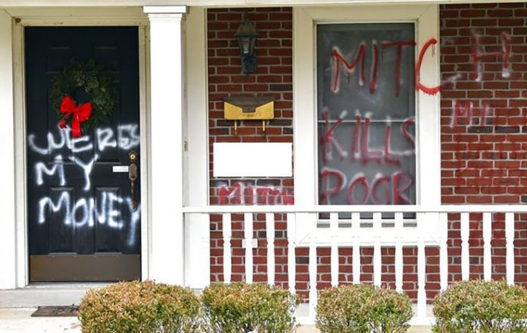 Spray paint on Senate Majority Leader Mitch McConnell’s door in Kentucky on Saturday read, “WERES MY MONEY.” “MITCH KILLS THE POOR”