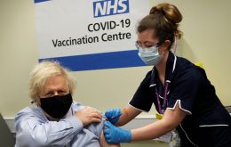 Pictures showed the prime minister wearing a black mask, a shirt and tie with his sleeve rolled up while a nurse gives him the vaccine. (Reuters)