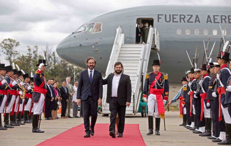 President Gabriel Boric (C-R) walks next to Argentinian Minister of Foreign Affairs Santiago Cafiero upon his arrival in Buenos Aires