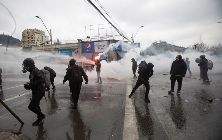 Some demonstrators threw Molotov cocktails at Carabineros police. Boric insisted dialogue was the way. Photo: Carlos Vera / Reuters