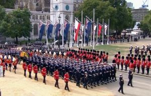 The coffin of HM Queen Elizabeth II passes the Falkland Islands flag and those of the other UK Overseas Territories and Crown Dependencies.