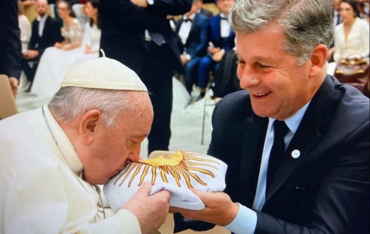 The Pope kisses and blesses the Argentine flag held by Esteban  (Pic E. estaban LN)